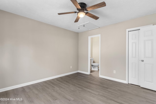 unfurnished bedroom featuring hardwood / wood-style flooring, ceiling fan, and connected bathroom