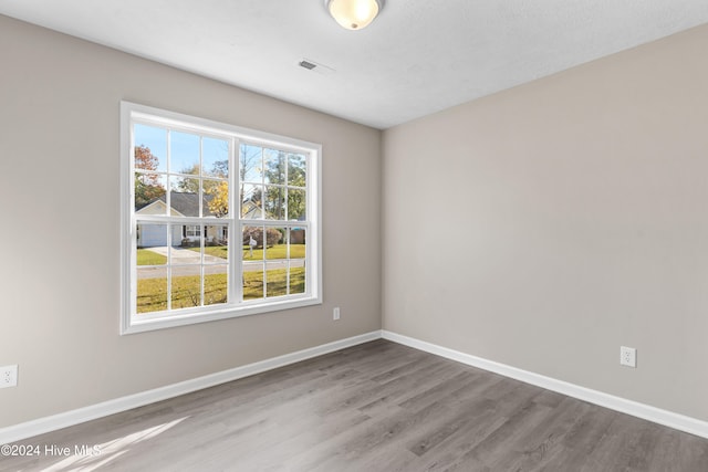 spare room with a textured ceiling and hardwood / wood-style flooring