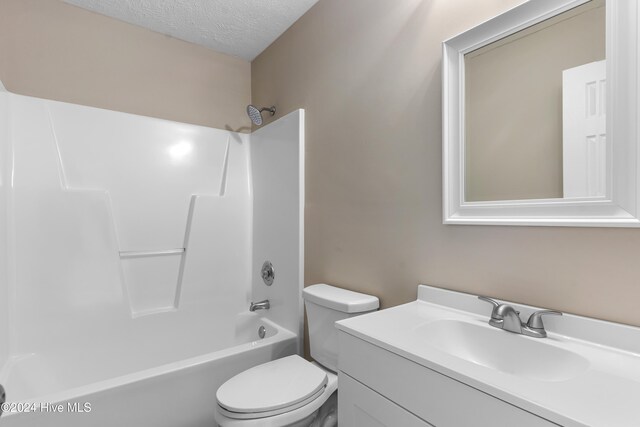 full bathroom with washtub / shower combination, vanity, a textured ceiling, and toilet