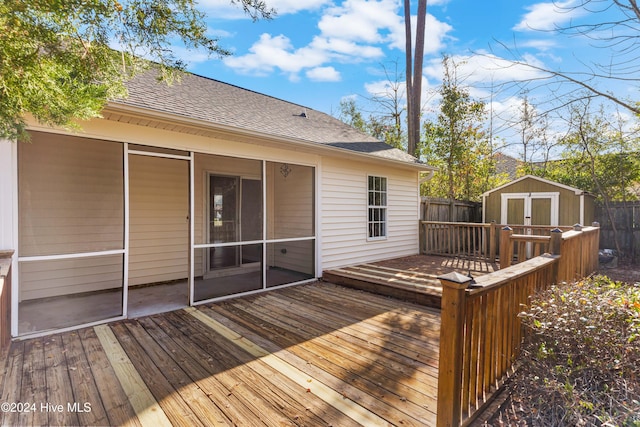 wooden terrace featuring a sunroom and a storage shed