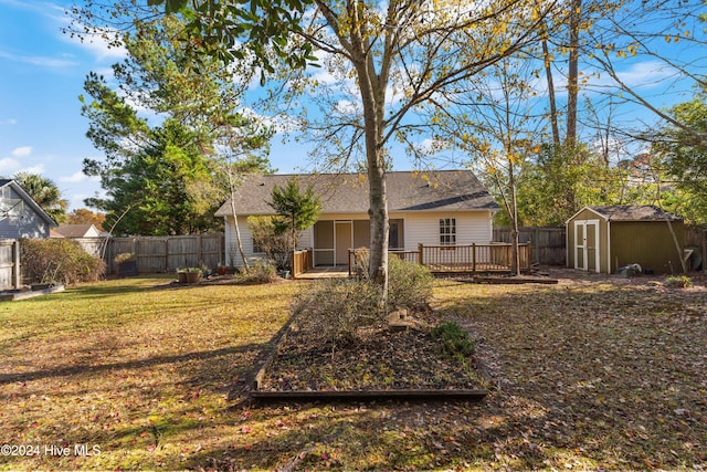 rear view of house with a wooden deck and a shed