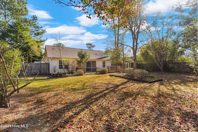 rear view of house with a yard and a shed