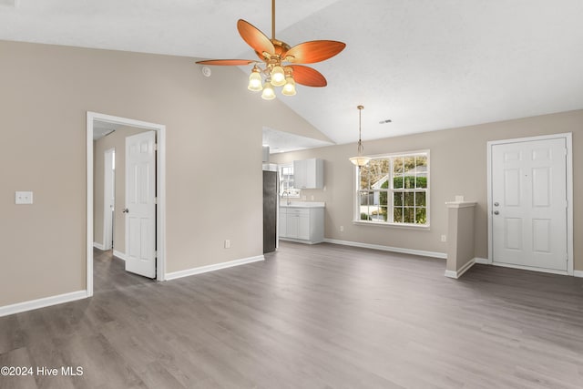 unfurnished living room with ceiling fan, high vaulted ceiling, and dark wood-type flooring