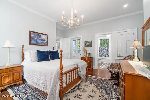 bedroom featuring light hardwood / wood-style floors, crown molding, and an inviting chandelier