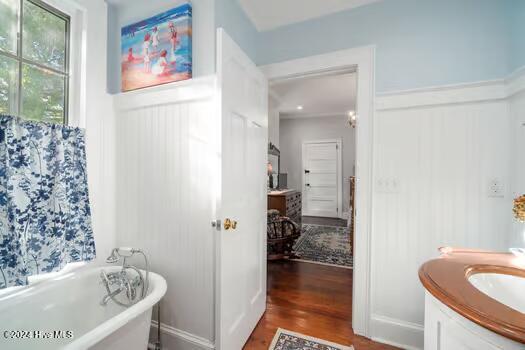 bathroom featuring hardwood / wood-style floors, a bathtub, and vanity