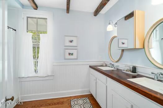 bathroom featuring hardwood / wood-style floors, beamed ceiling, and vanity