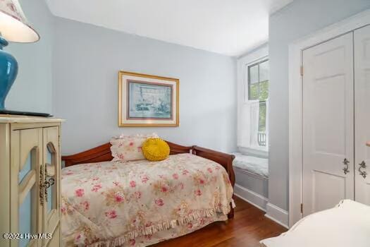 bedroom featuring dark hardwood / wood-style floors and a closet