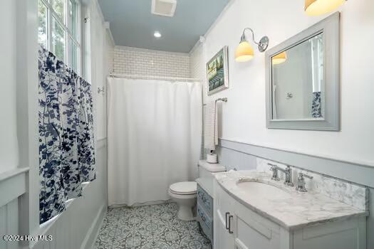 bathroom featuring walk in shower, vanity, and toilet