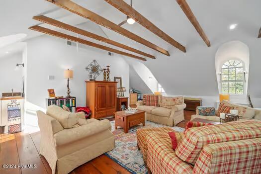 living room with light wood-type flooring and vaulted ceiling with beams