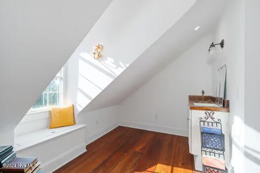 bonus room with dark hardwood / wood-style floors and vaulted ceiling