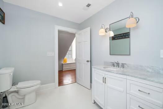 bathroom featuring hardwood / wood-style floors, vanity, and toilet