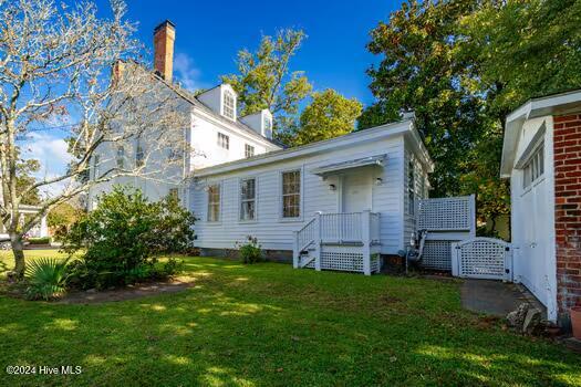 rear view of house featuring a yard