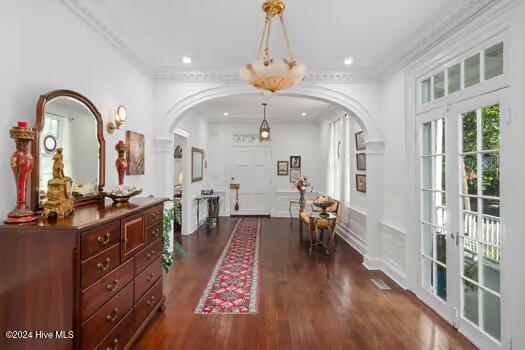 foyer with french doors, crown molding, and dark hardwood / wood-style flooring