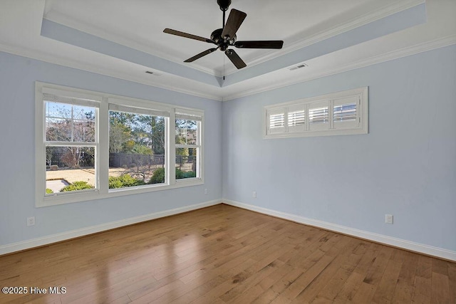 unfurnished room featuring crown molding, a tray ceiling, light hardwood / wood-style floors, and ceiling fan