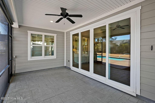 unfurnished sunroom with ceiling fan