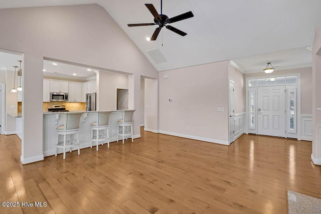 interior space featuring white cabinetry, appliances with stainless steel finishes, light wood-type flooring, and kitchen peninsula