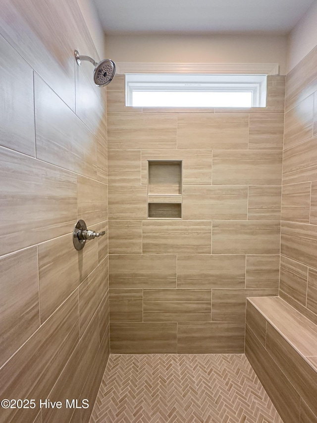 bathroom featuring tiled shower and plenty of natural light