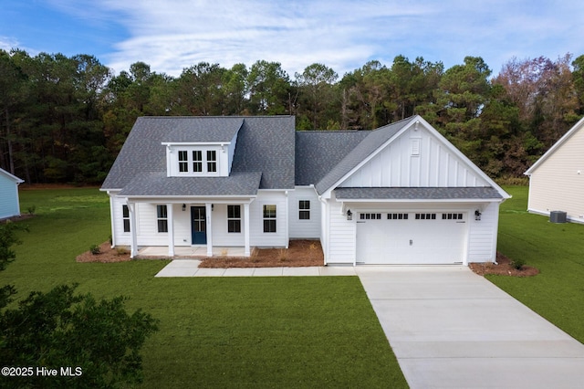 view of front facade featuring a garage, a front yard, covered porch, and cooling unit