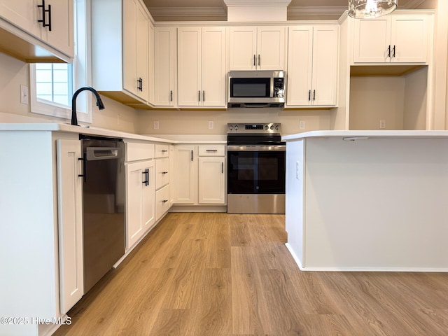 kitchen featuring light wood-type flooring, white cabinets, and appliances with stainless steel finishes