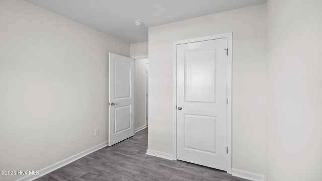 unfurnished bedroom with baseboards and wood finished floors