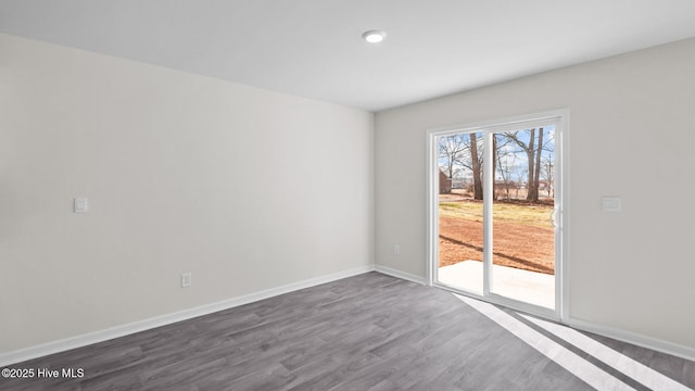 empty room with dark wood finished floors and baseboards