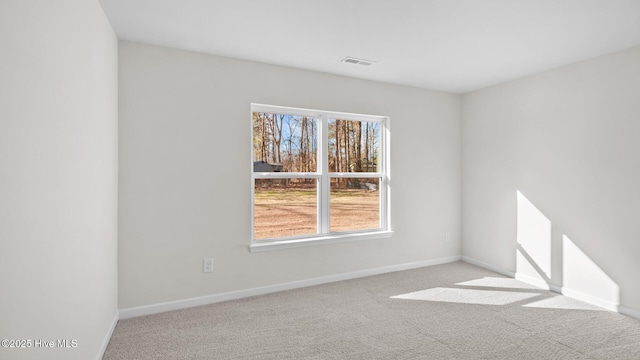 carpeted empty room with visible vents and baseboards