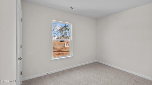 empty room with a wealth of natural light, baseboards, visible vents, and carpet flooring