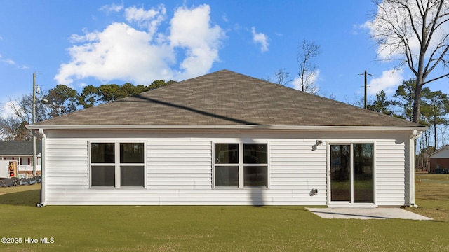 rear view of property with a shingled roof and a yard