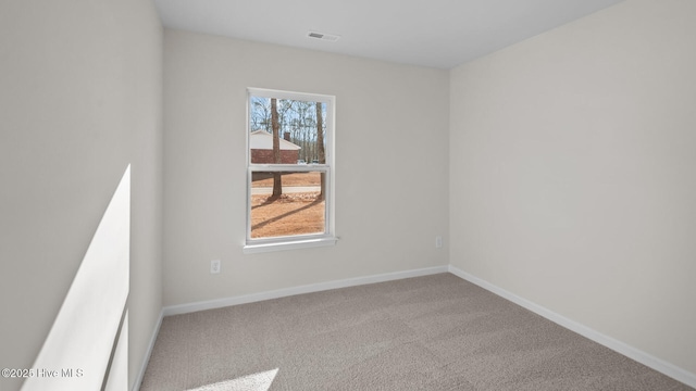 carpeted empty room featuring visible vents and baseboards