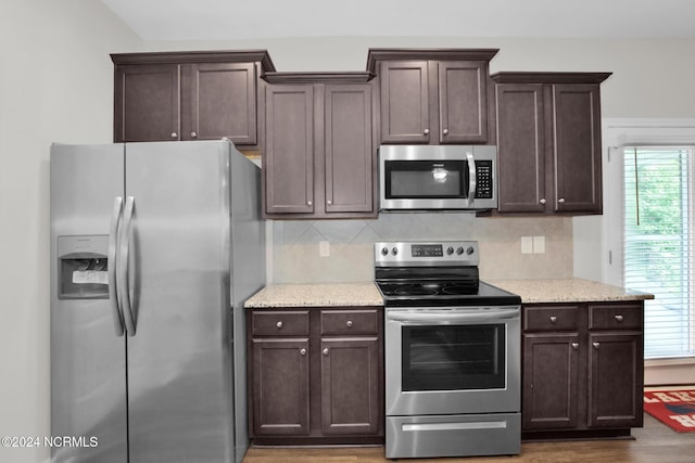 6639 Ramsey St, Fayetteville, NC 28311 - kitchen with stainless steel appliances, dark brown cabinetry, tasteful backsplash, light stone counters, and wood finished floors