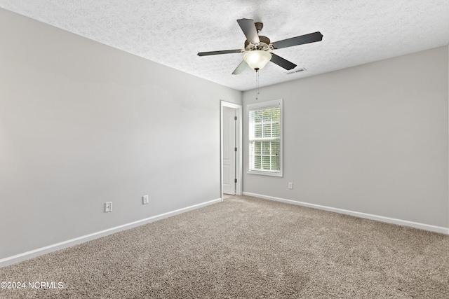 carpeted empty room with ceiling fan and a textured ceiling