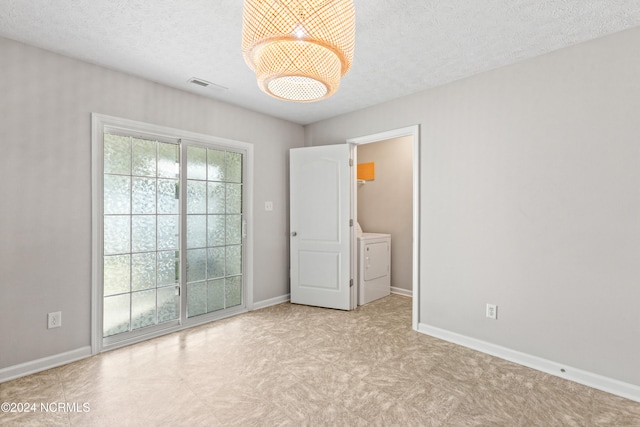 spare room with washer / dryer and a textured ceiling