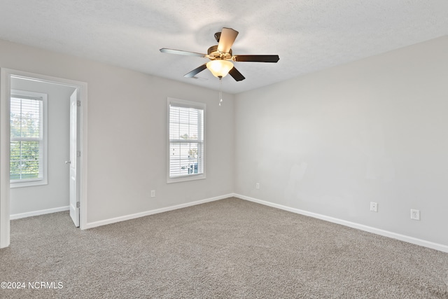 carpeted empty room featuring a textured ceiling and ceiling fan