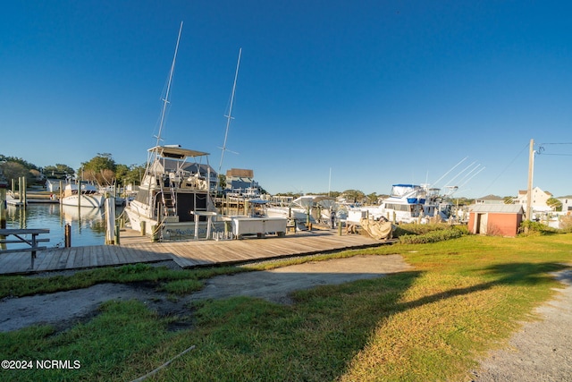 view of dock with a yard and a water view