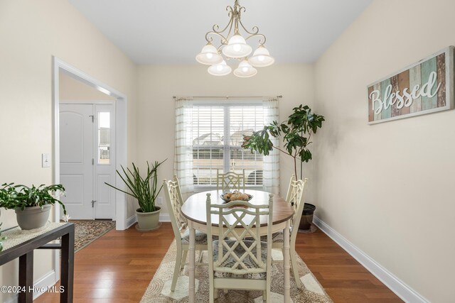 dining area with dark hardwood / wood-style flooring and a chandelier