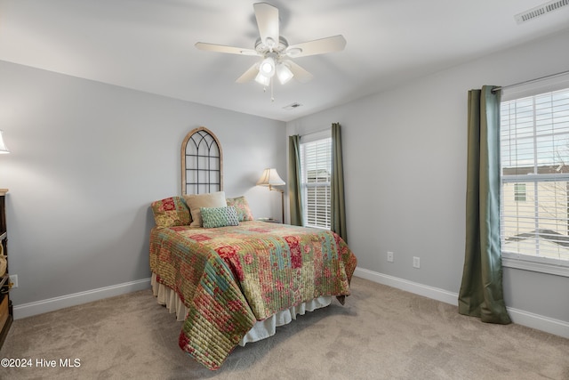 carpeted bedroom with ceiling fan and multiple windows