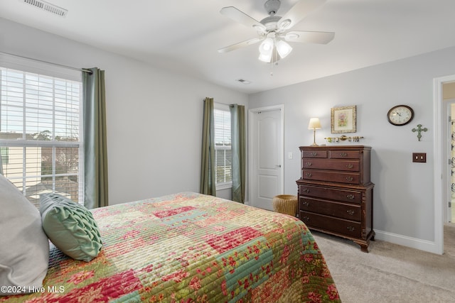 carpeted bedroom featuring ceiling fan and multiple windows