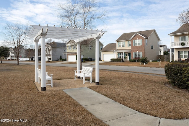 view of community featuring a yard and a pergola