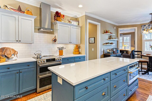 154 Horizon Trl, Aberdeen, NC 28315 - kitchen featuring wall chimney range hood, stainless steel appliances, blue cabinetry, crown molding, and recessed lighting