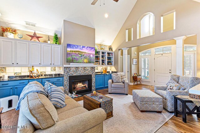 154 Horizon Trl, Aberdeen, NC 28315 - living room with decorative columns, high vaulted ceiling, wood finished floors, ceiling fan, and a tiled fireplace