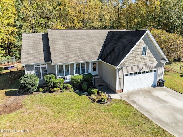 cape cod home with a front yard and a garage