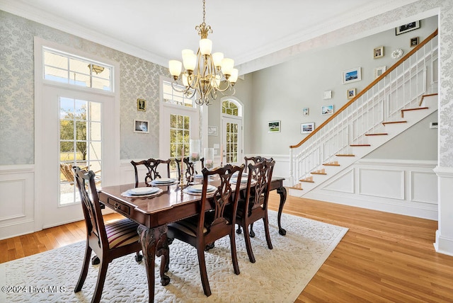 dining area featuring hardwood / wood-style floors, crown molding, and an inviting chandelier