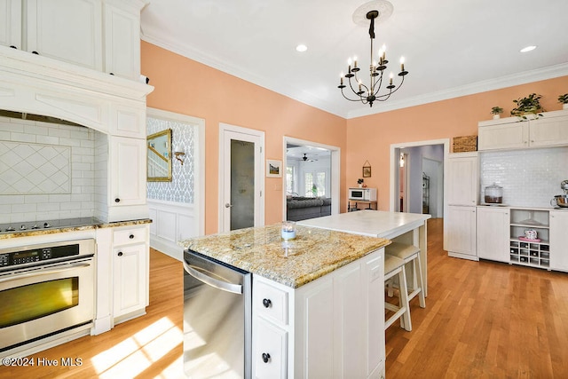 kitchen with a kitchen island, pendant lighting, white cabinets, and stainless steel appliances