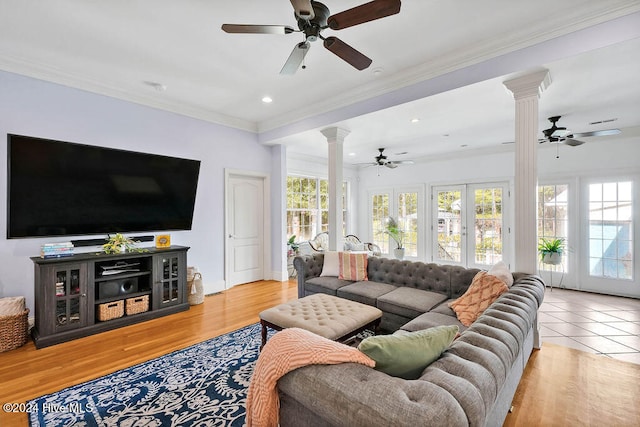 living room featuring ceiling fan, ornate columns, light wood-type flooring, and ornamental molding