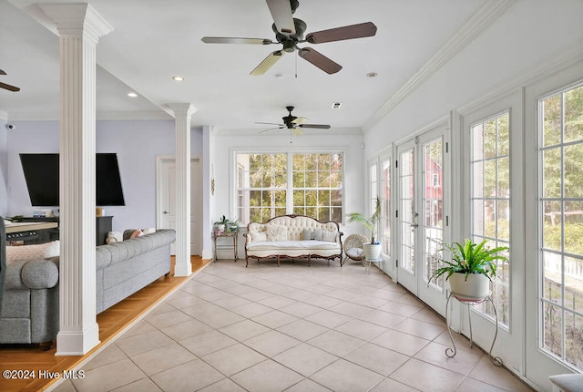 unfurnished sunroom featuring decorative columns, french doors, and ceiling fan