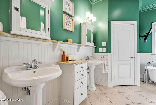 bathroom with dual sinks, tile patterned floors, and crown molding