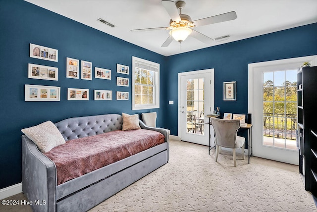 bedroom featuring multiple windows, ceiling fan, and access to exterior