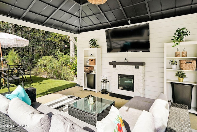 living room with concrete flooring, wooden walls, and an outdoor stone fireplace