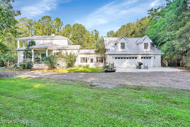 view of front of home featuring a garage, a front lawn, and covered porch