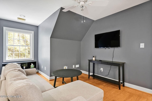 living room featuring ceiling fan, light wood-type flooring, and lofted ceiling